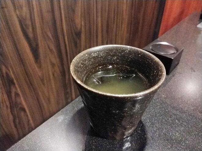 黒い湯飲みに注がれた緑茶